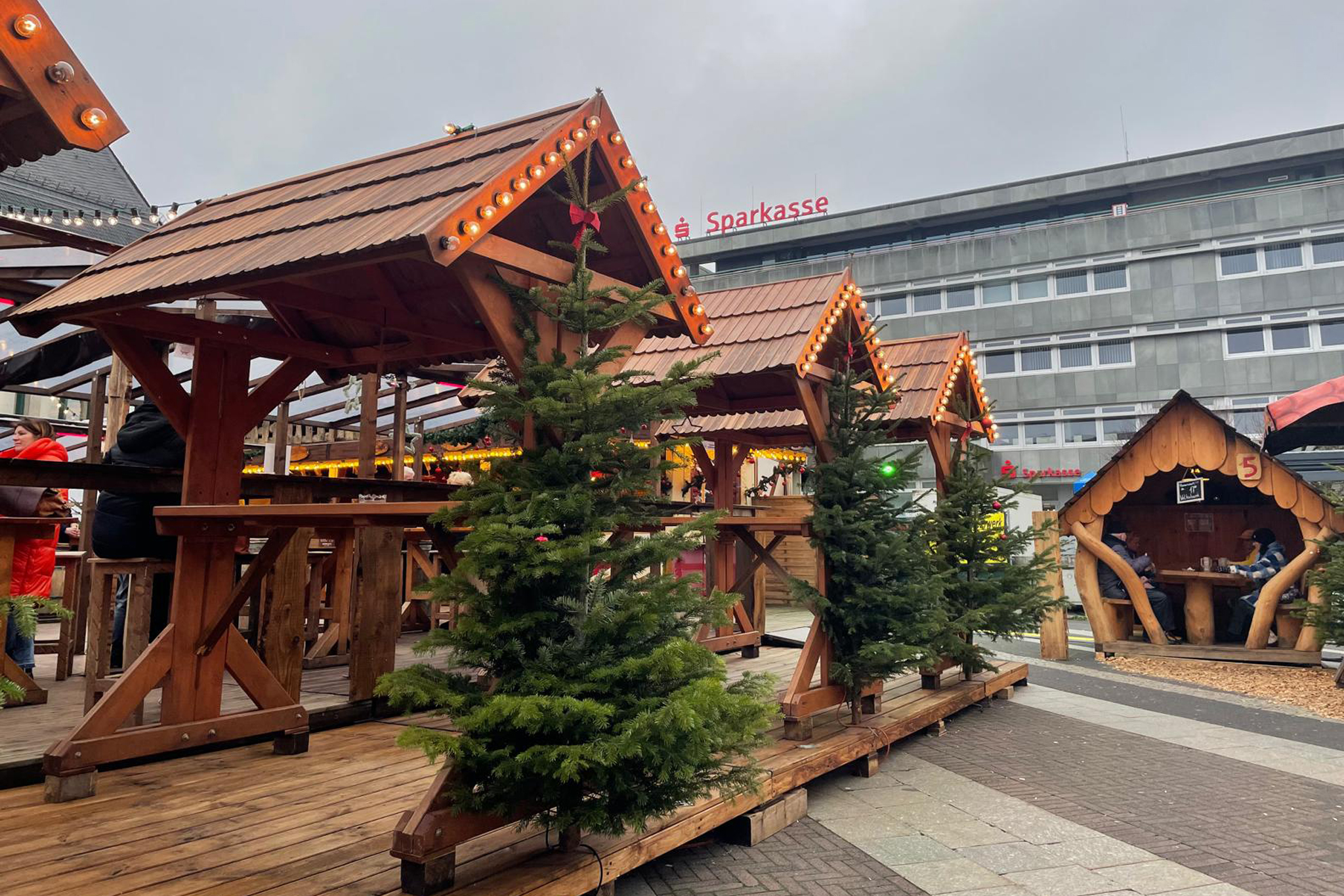 Mehrere Holzpavillons auf dem Remscheider Weihnachtstreff mit Sitzmöglichkeiten